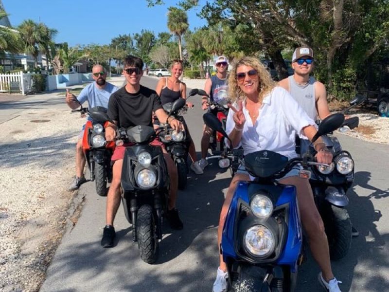 Group rides Vespa-style scooters on street