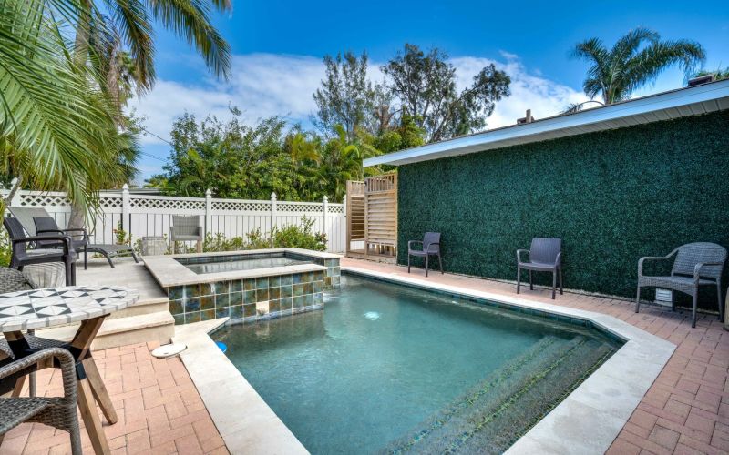 Vacation rental with pool surrounded by palm trees