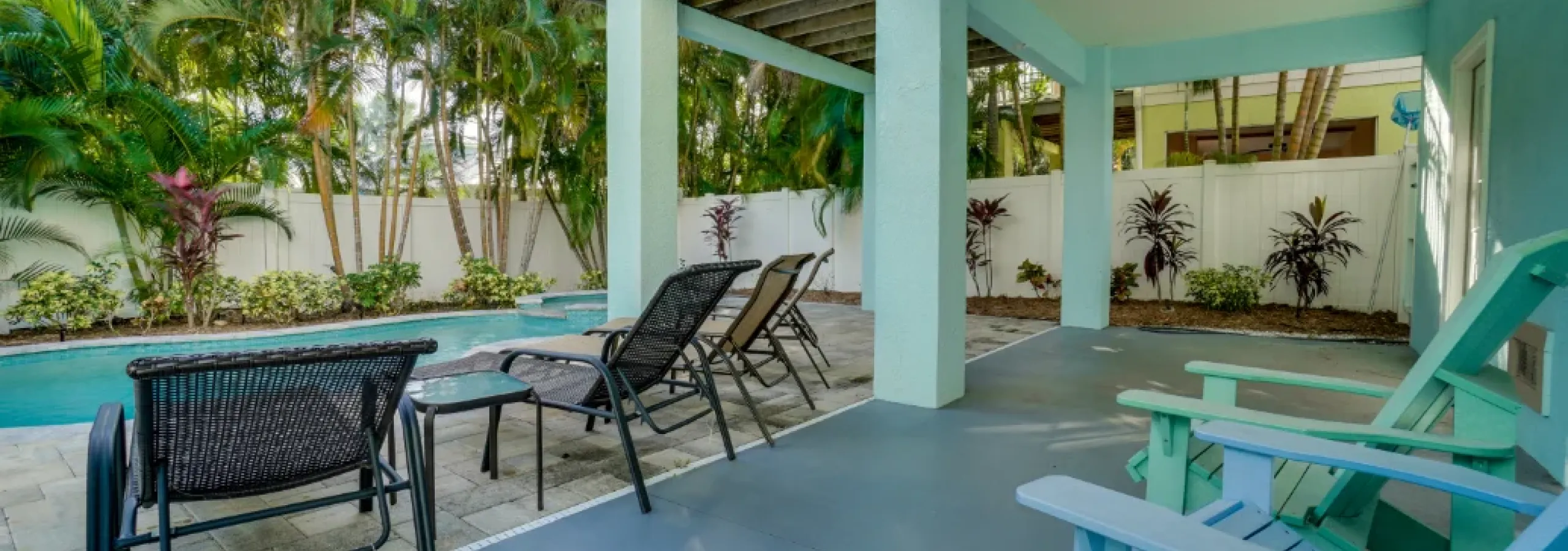 Vacation rental porch with turquoise doors and lounge seating