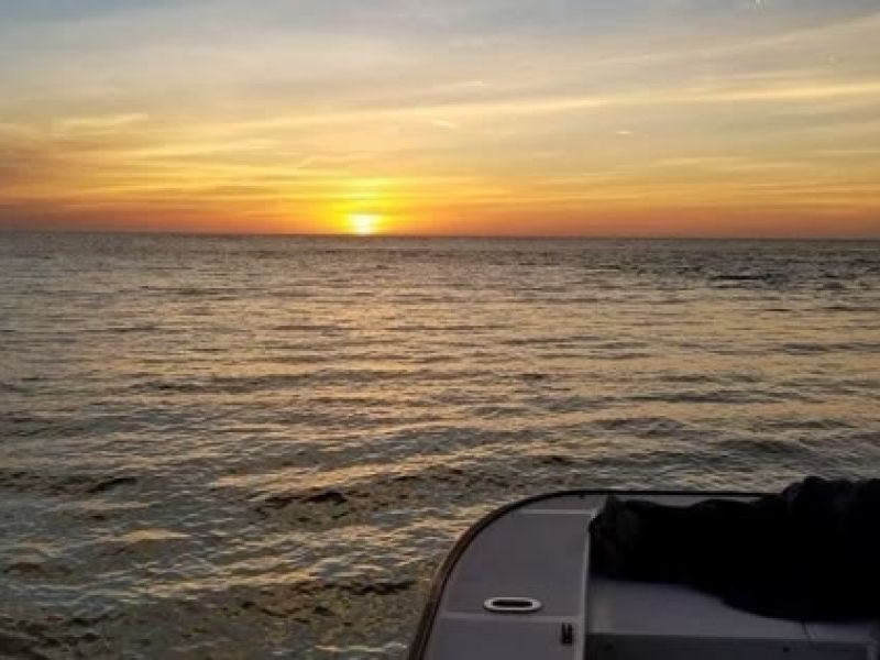 Golden sunset over ocean viewed from boat