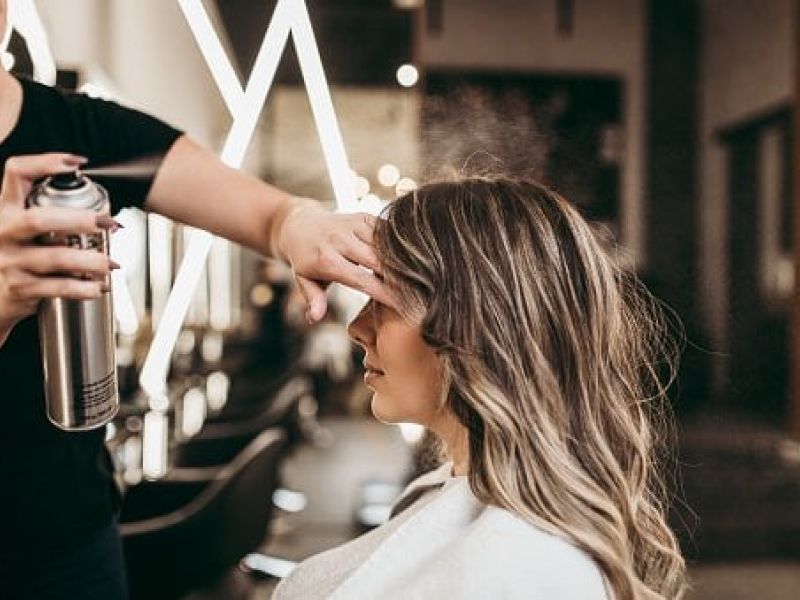 Hairstylist styling client's hair in salon