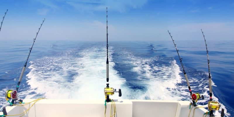 Fishing boat with multiple rods extended at sea