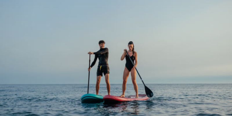 Two people paddleboard in the ocean