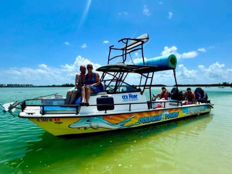 Colorful fishing boat full of people in bay