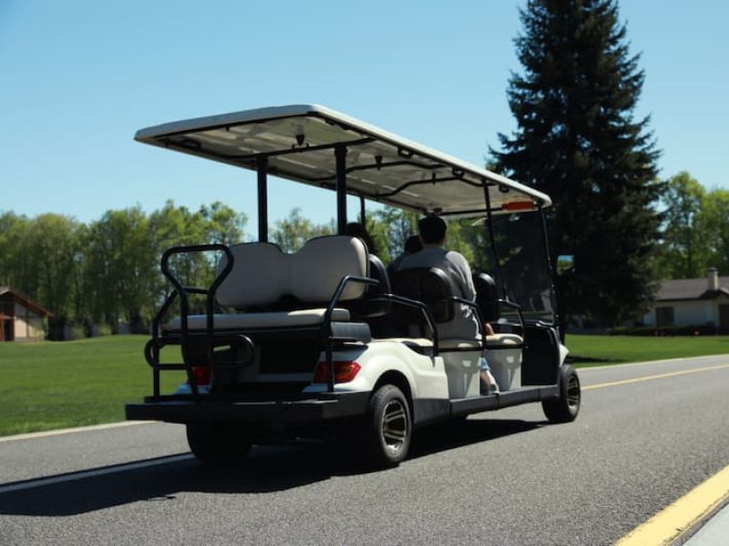 White golf cart on resort grounds with green grass