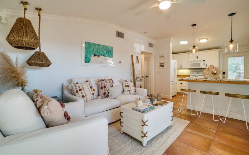Bright living room in vacation rental with gray sofa and kitchen
