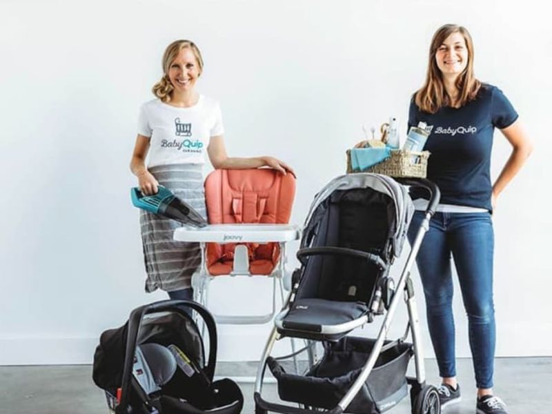 Two people with vacation luggage and baby stroller