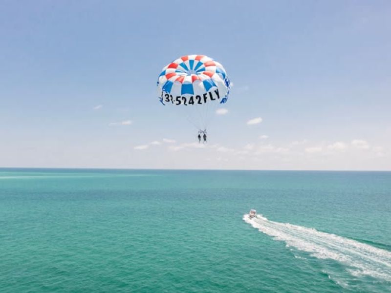 Parasail with person pulled behind a boat