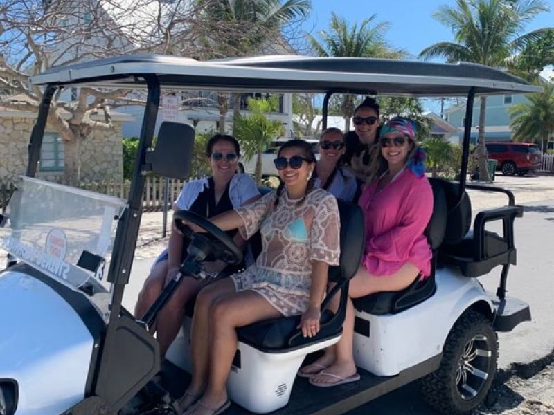 Family rides golf cart on a beach