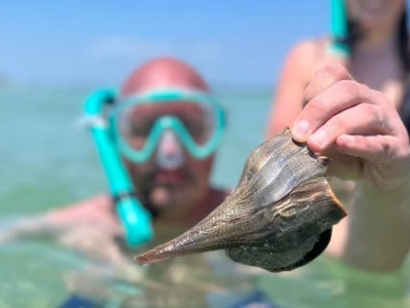Snorkeler holds up a fish in water