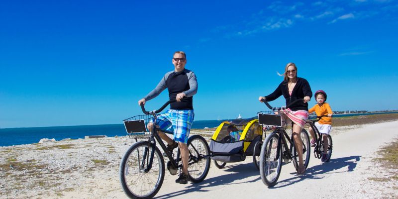 People ride bicycles on the beach together