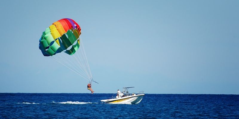 Colorful parachute trails behind a boat at sea