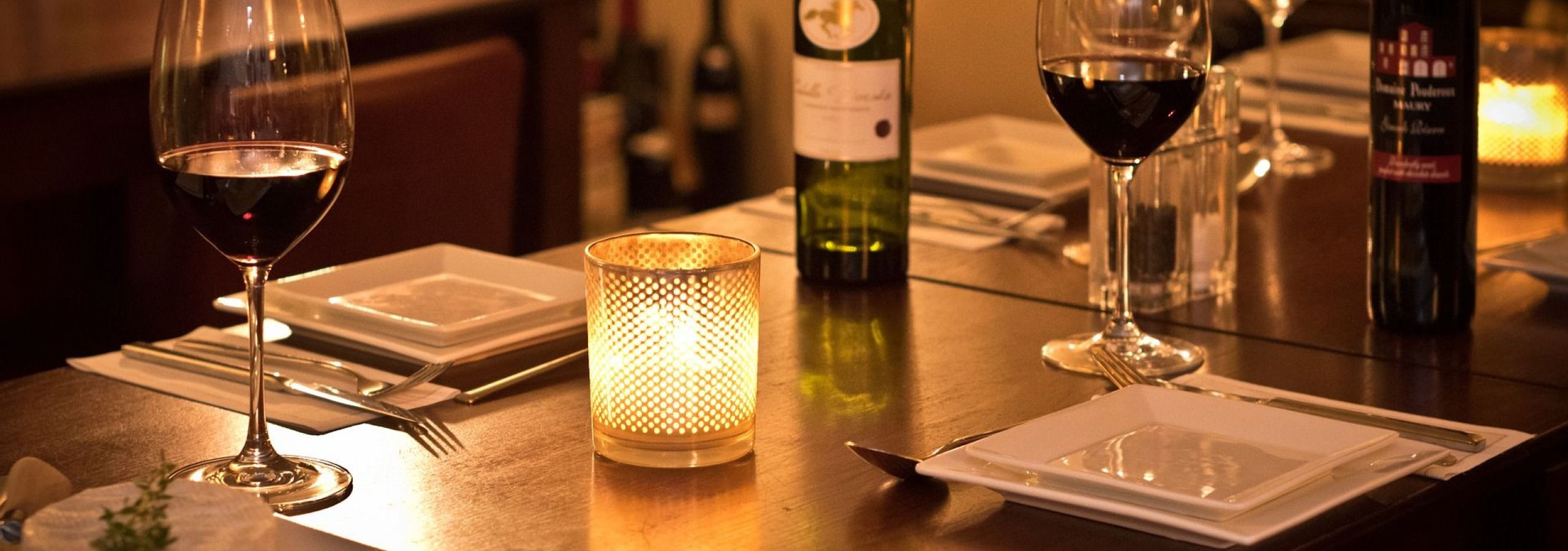 Wine bottles and glasses on wooden dining table