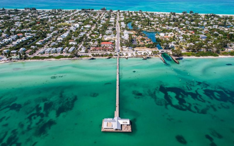 Aerial view of turquoise water and white sailboat