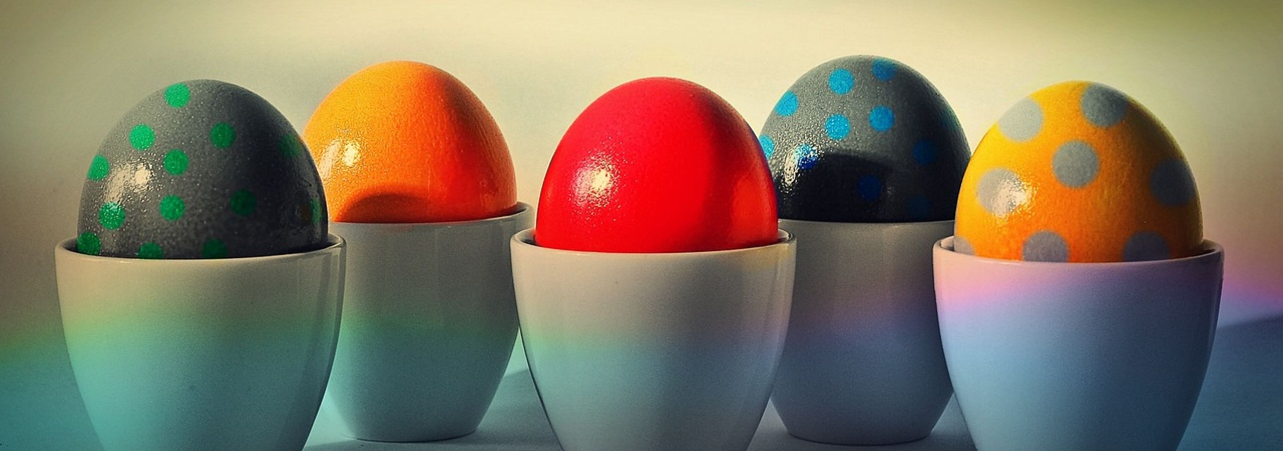 Colorful Easter eggs displayed in pastel eggcups