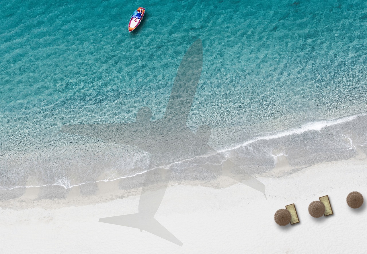 Aerial view of boat anchored in turquoise water near white sand
