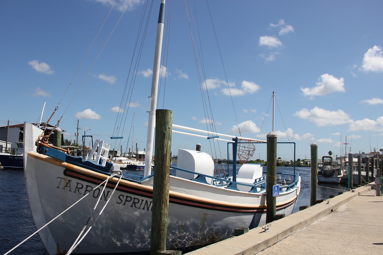 Sailboat docked at marina under blue sky