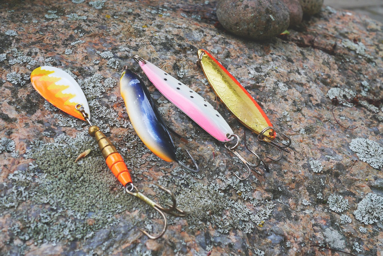 Colorful fishing lures arranged on rocks