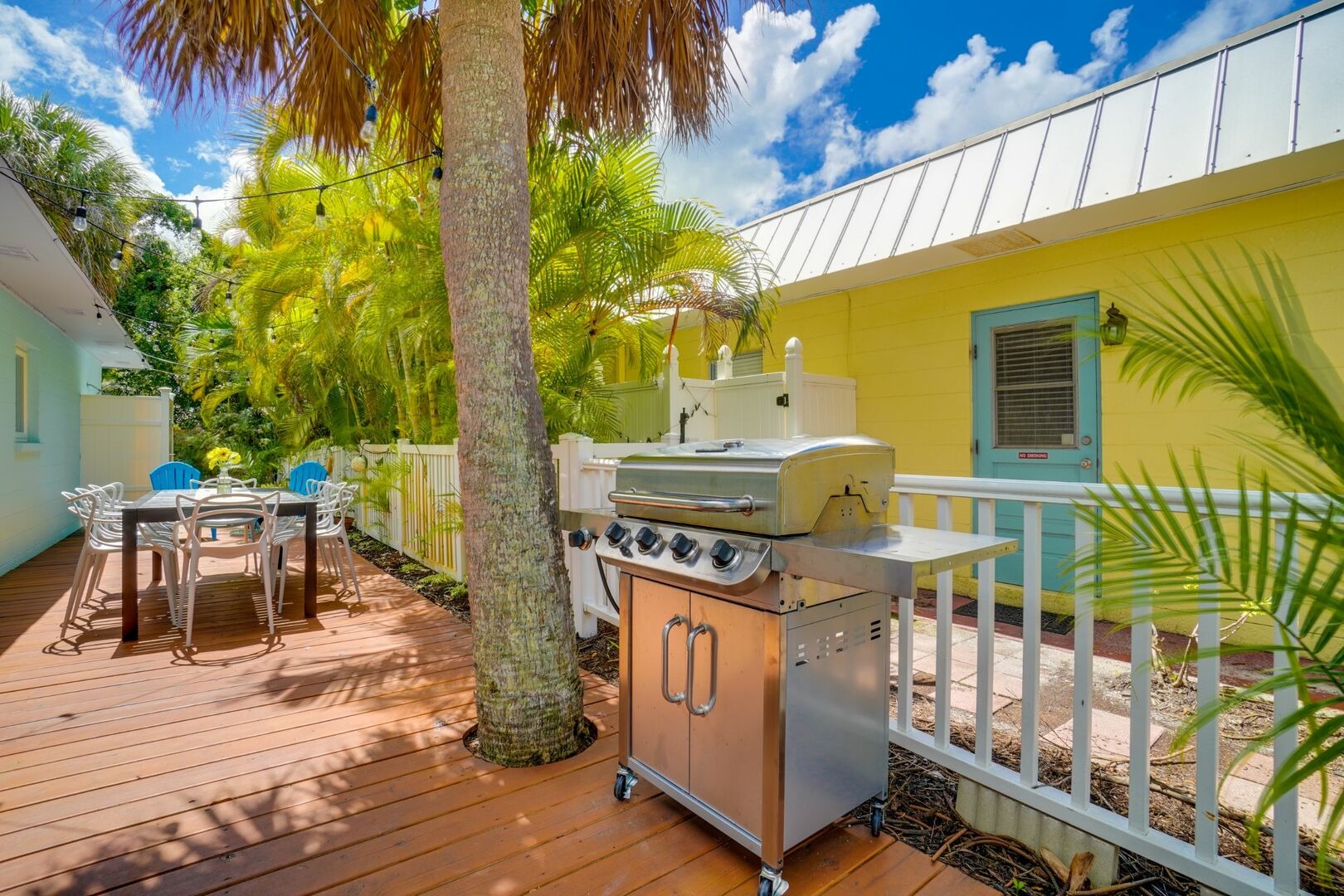 Wooden deck with outdoor grill surrounded by palms