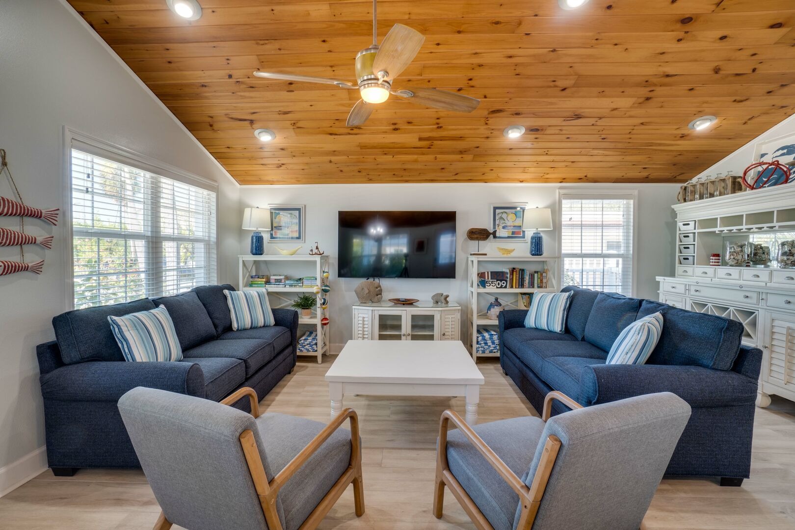 Spacious living room with wood ceiling and blue upholstered seating