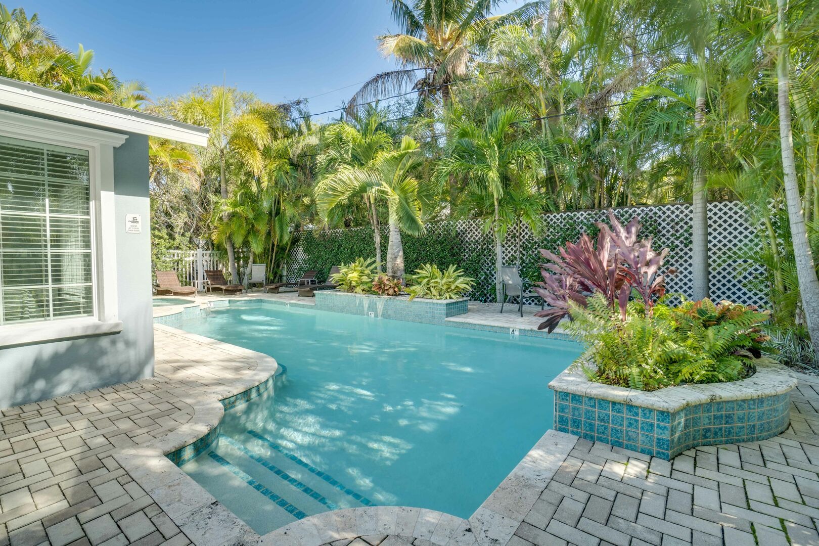 Vacation rental with resort-style pool and lush tropical landscaping