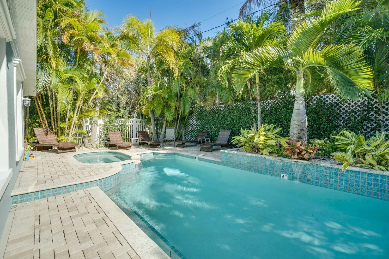 Resort-style swimming pool with palm trees and lounge chairs