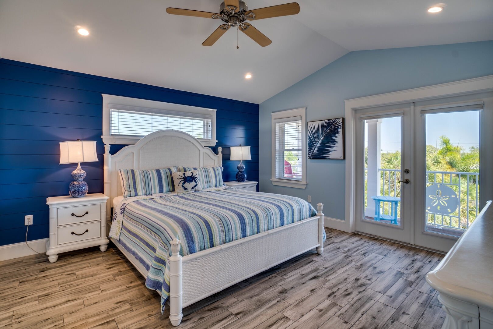 Bright master bedroom with blue walls and water view