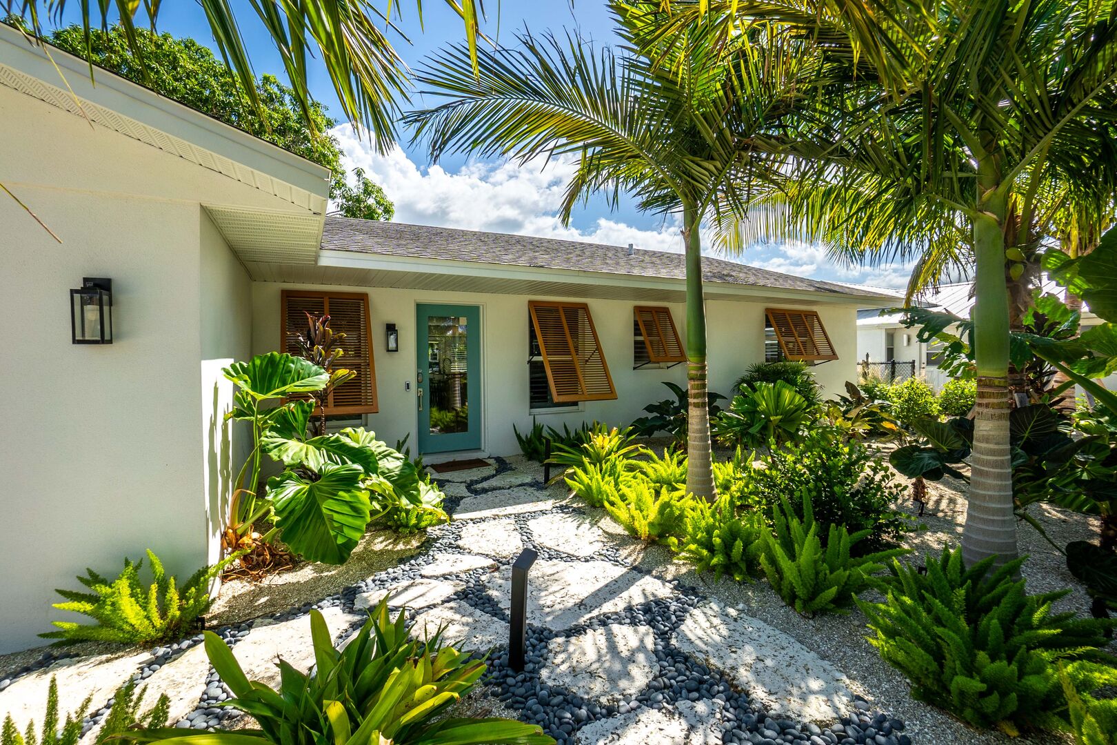 Modern vacation rental with tropical landscaping and covered patio