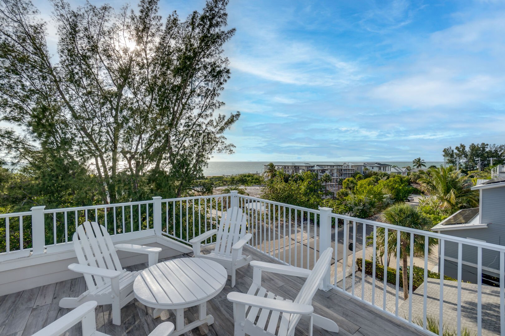White Adirondack chairs on deck with expansive landscape views