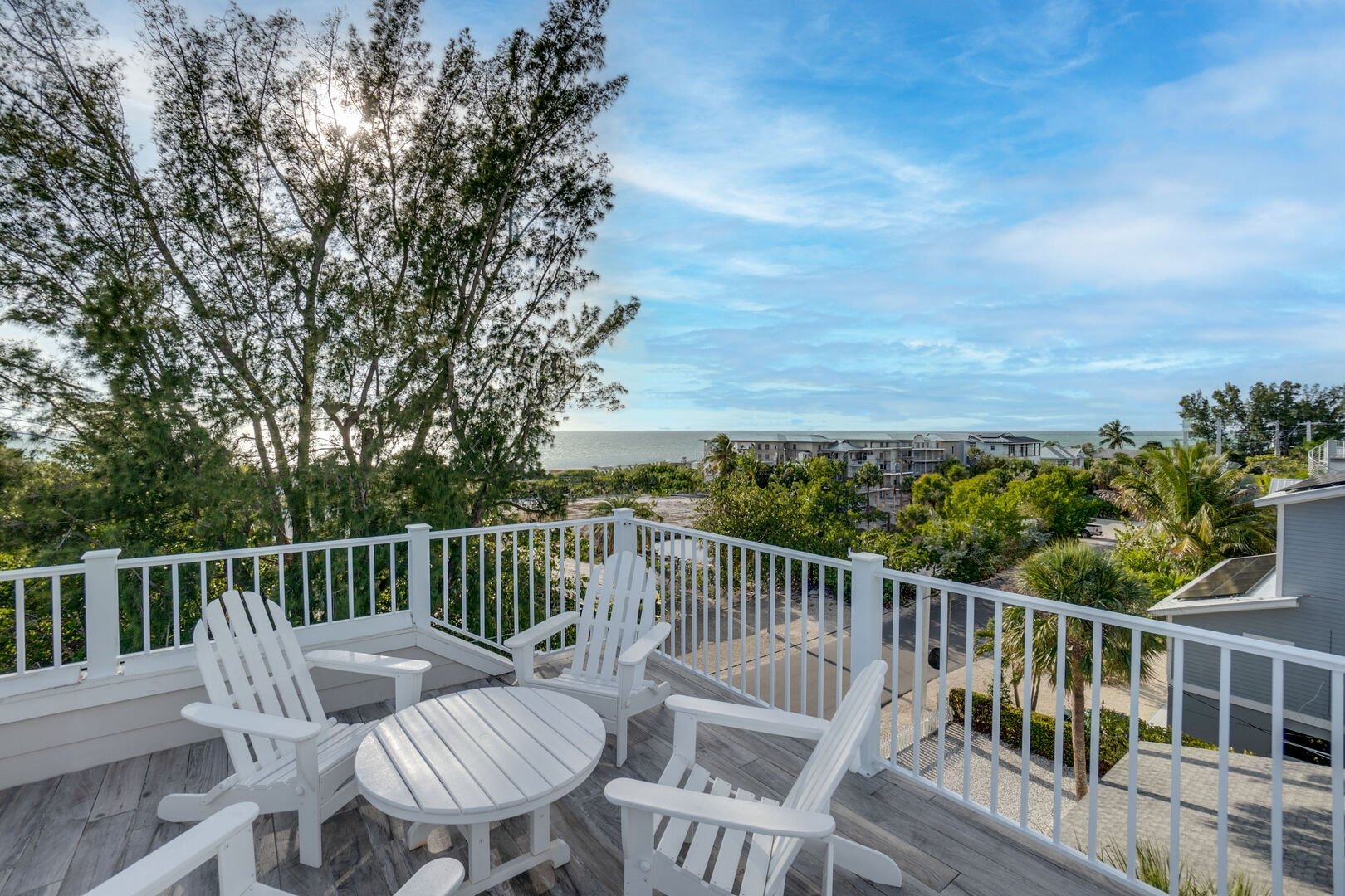 White Adirondack chairs on elevated deck with scenic view