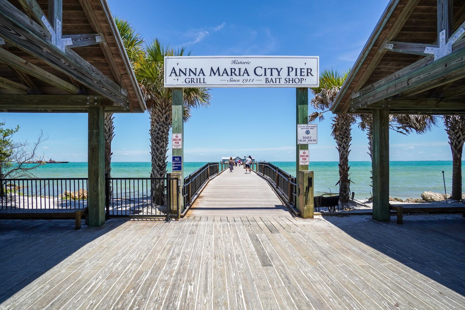 Wooden pier extending beneath covered structure to water