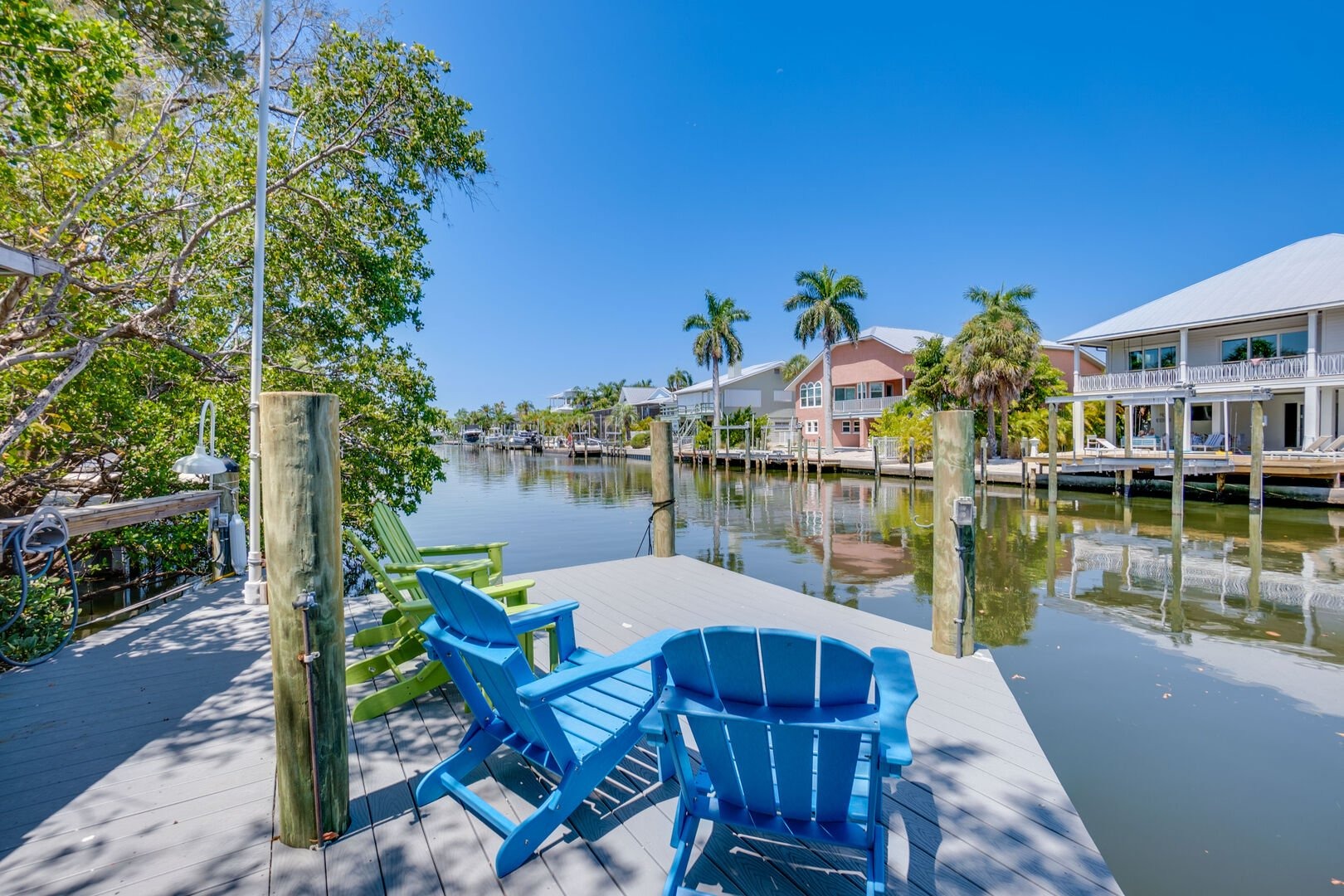 Blue Adirondack chairs on dock overlooking waterway