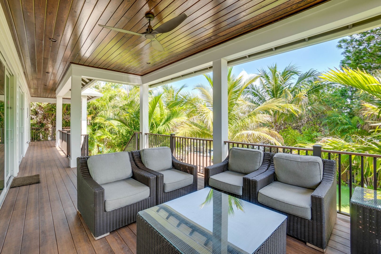 Covered porch with rattan furniture overlooking garden