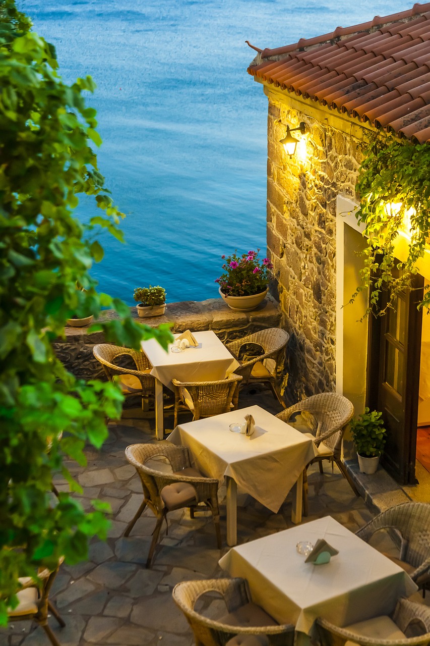 Waterfront restaurant dining area with sea views and vibrant plants