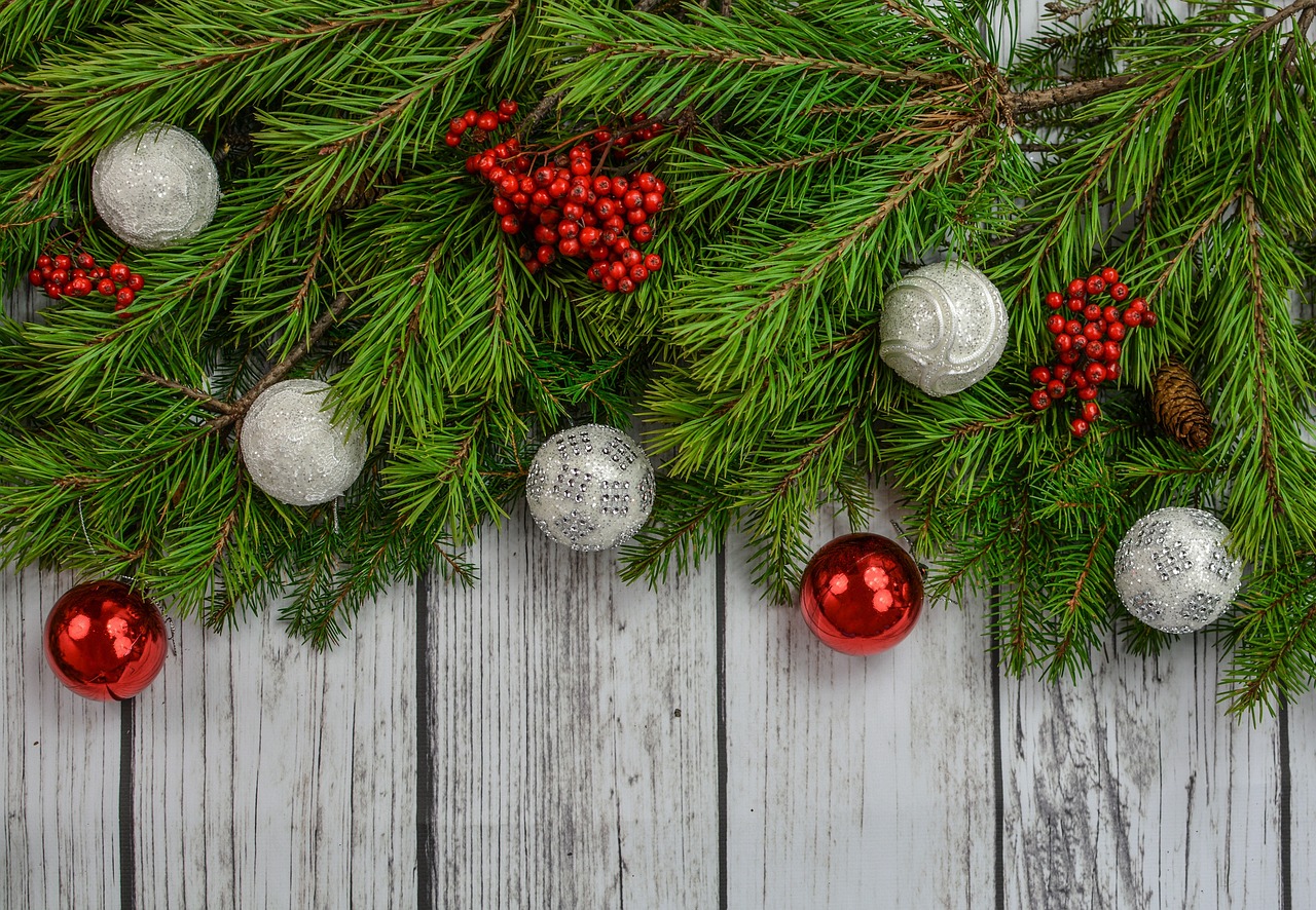 Christmas wreath with ornaments on white wood