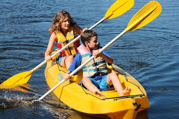 Woman and child kayaking together on blue water