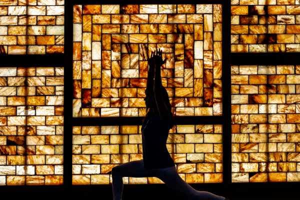 Silhouette against illuminated golden brick architectural backdrop