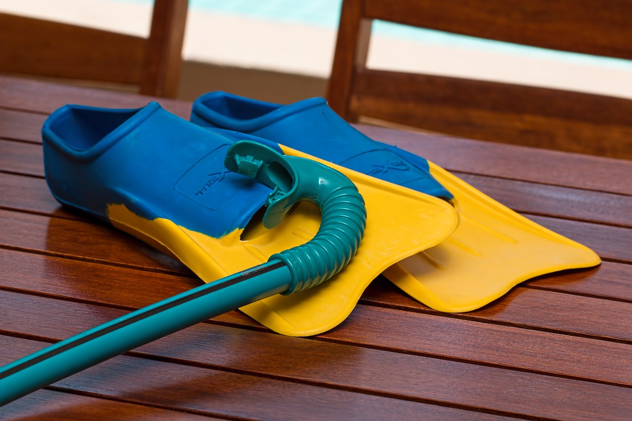 Snorkeling fins and mask on weathered wooden dock